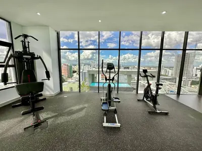 a gym with cardio equipment in a room with windows at Stunning City Center Condo in Los Prados