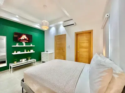 a bedroom with a green wall and a bed at Stunning City Center Condo in Los Prados