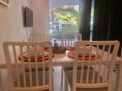 a dining room table with two chairs and a table with plates on it at Estrella Dominicus con hermosa piscina! 1st floor in La Laguna