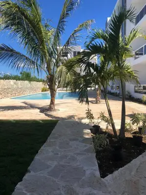 two palm trees in front of a swimming pool at Sol Caribe 101 Bayahibe con linda piscina! in Bayahibe