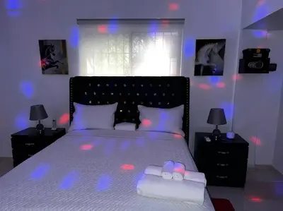 a bedroom with a bed with purple lights on it at Entire apartment Tu Nido De Amor 2 Santo Domingo West in Santo Domingo