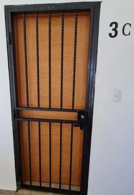 a wooden door with a black metal gate at Apartaestudio en el centro de Puerto Plata in San Felipe de Puerto Plata