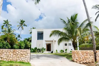 a white house with palm trees in front of it at Private Villa 4 BR at Playa Bonita, Las Terrenas in Las Terrenas