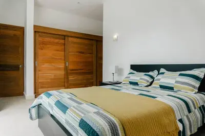 a bedroom with a bed with a striped blanket at Private Villa 4 BR at Playa Bonita, Las Terrenas in Las Terrenas