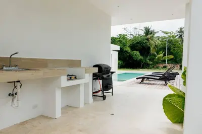 a white kitchen with a counter and a pool at Private Villa 4 BR at Playa Bonita, Las Terrenas in Las Terrenas