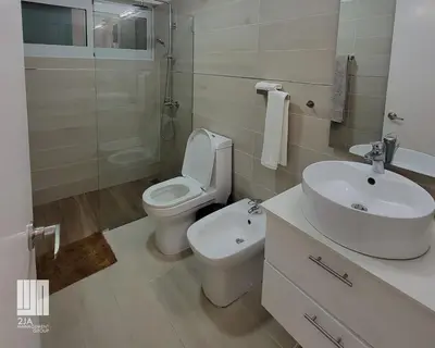 a white bathroom with a toilet and a sink at 2JA Management Group - Condos White Hill in Sosúa