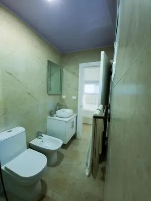 a bathroom with a white toilet and a sink at 2JA Management Group - Condos White Hill in Sosúa