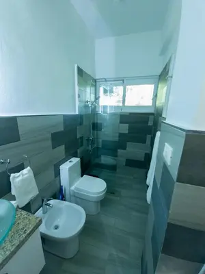 a bathroom with a white toilet and a sink at 2JA Management Group - Condos White Hill in Sosúa