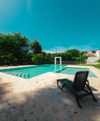 a chair sitting in front of a swimming pool at 2JA Management Group - Condos White Hill in Sosúa