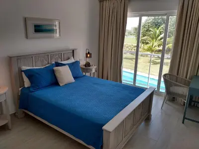 a bedroom with a bed with blue sheets and a window at Hard Rock at Cana Pearl 1 by Unwind Properties in Punta Cana