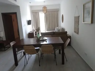 a dining room table and chairs in a living room at Hard Rock at Cana Pearl 1 by Unwind Properties in Punta Cana