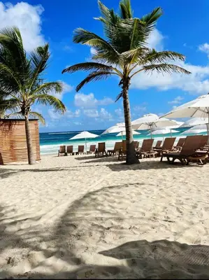 a beach with chairs and umbrellas on the beach at Hard Rock at Cana Pearl 1 by Unwind Properties in Punta Cana