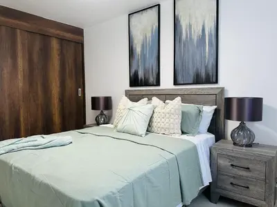 a bedroom with a bed and two lamps on a nightstand at Rustic Elegance St in Santiago de los Caballeros