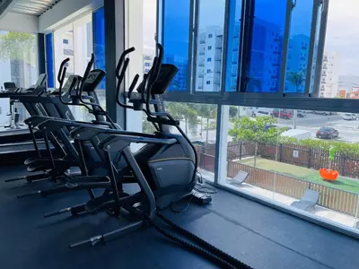 a row of treadmills in a gym next to a window at Rustic Elegance St in Santiago de los Caballeros