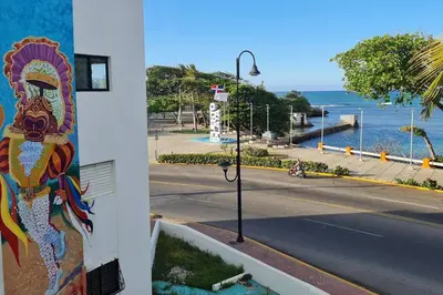 a building with a painting on the side of a street at Apartament central frente al mar in San Felipe de Puerto Plata