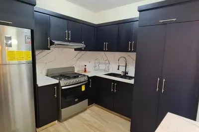 a kitchen with dark blue cabinets and a stove at Apartament central frente al mar in San Felipe de Puerto Plata