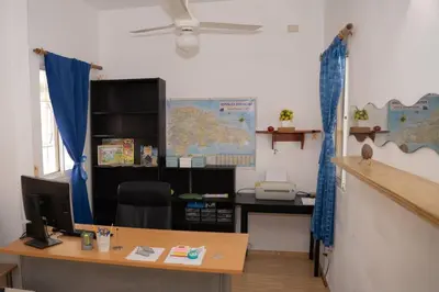 an office with a desk with a computer and blue curtains at Villa Caribe in Bayahibe