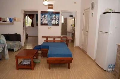 a living room with a couch and tables and a refrigerator at Villa Caribe in Bayahibe