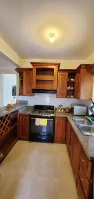 a kitchen with wooden cabinets and a stove top oven at Pine Tree Entire House 2B Gated Com in Higuey
