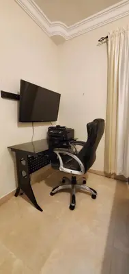 a computer desk with a computer monitor and a chair at Pine Tree Entire House 2B Gated Com in Higuey