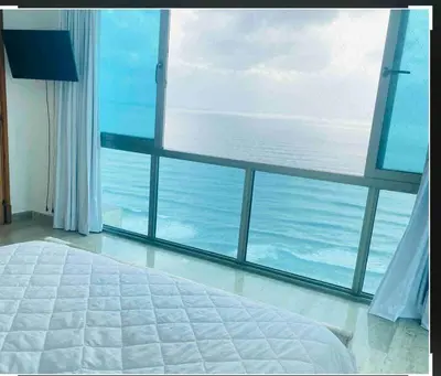 a bedroom with a large bed and a large window at Habitación Privada con vista al mar Ámbar, Malecon Santo Domingo in Santo Domingo