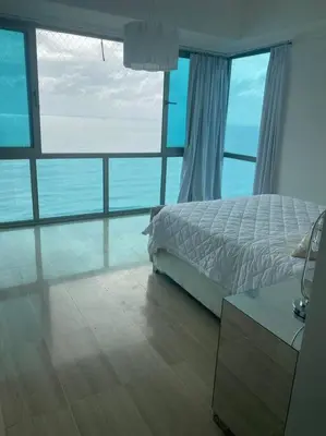 a bedroom with a bed and a view of the ocean at Habitación Privada con vista al mar Ámbar, Malecon Santo Domingo in Santo Domingo