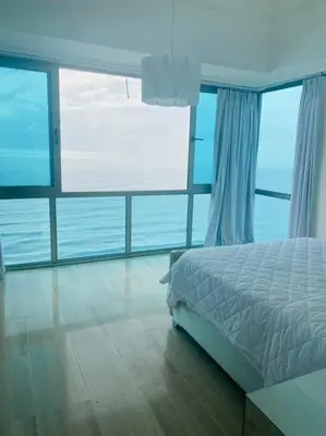 a bedroom with a bed and a view of the ocean at Habitación Privada con vista al mar Ámbar, Malecon Santo Domingo in Santo Domingo