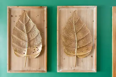 two leaves on a wooden cutting board on a green wall at Stunning infinity pool apartment in Santo Domingo