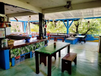 a restaurant with a table and benches in a room at Hostel 23 in Las Terrenas