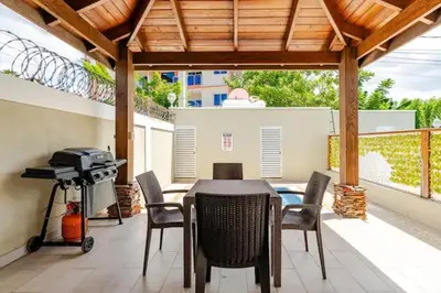 a patio with a table and chairs and a grill at Sky Blue in Jarabacoa