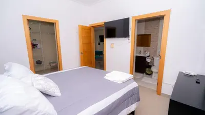 a bedroom with a large bed and a bathroom at Sky Blue in Jarabacoa