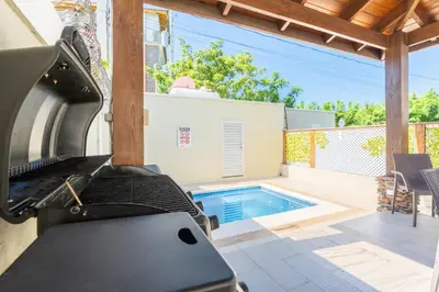 a barbecue grill in front of a swimming pool at Sky Blue in Jarabacoa