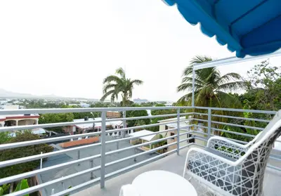 a balcony with chairs and a view of the ocean at MB Apartment - B in San Felipe de Puerto Plata