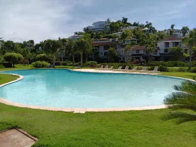 a large swimming pool with chairs in a yard at Bonita Village Beachfront Apt with Pool & Balcony in Las Terrenas