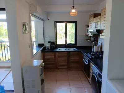 a kitchen with black counter tops and a window at Bonita Village Beachfront Apt with Pool & Balcony in Las Terrenas