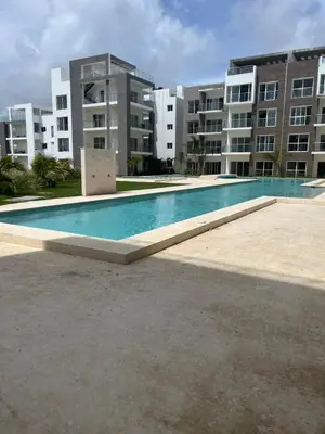 an empty swimming pool in front of a building at Hard Rock Punta Cana Luxe Apartment 2BR Coral Bay by BTC Crypto Group in Punta Cana