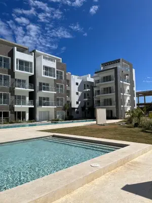 a swimming pool in front of two apartment buildings at Hard Rock Punta Cana Luxe Apartment 2BR Coral Bay by BTC Crypto Group in Punta Cana