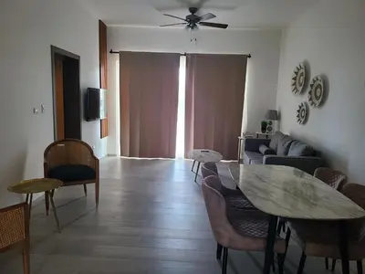 a living room with a table and a couch at Hard Rock Punta Cana Luxe Apartment 2BR Coral Bay by BTC Crypto Group in Punta Cana