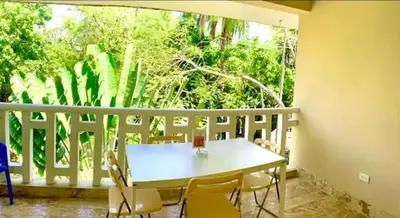 a table and chairs on a balcony with a window at Paradis Mimies Dominican Bay in Boca Chica