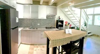 a kitchen with a table and a kitchen with white cabinets at Paradis Mimies Dominican Bay in Boca Chica