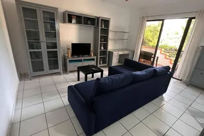 a living room with a blue couch and a television at Caribe Campo Sosua in Sosúa