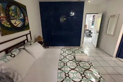 a bedroom with a large white bed and a blue door at Caribe Campo Sosua in Sosúa