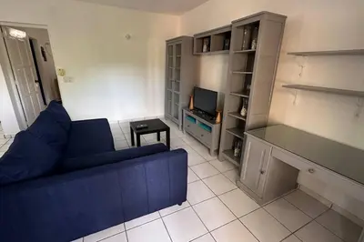 a living room with a blue couch and a tv at Caribe Campo Sosua in Sosúa