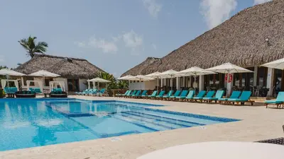 a resort swimming pool with chairs and umbrellas at Hard Rock Getaway • 2BR with Golf + Pool Views in Punta Cana