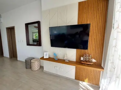 a living room with a flat screen tv on a wall at Hard Rock Getaway • 2BR with Golf + Pool Views in Punta Cana