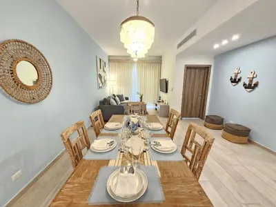 a dining room with a long table and chairs at 2BR Beach Condo • Prime Location Across Hard Rock in Punta Cana