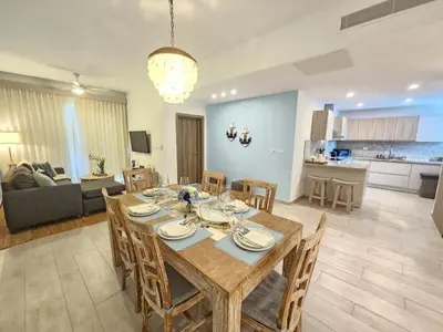 a dining room and living room with a table and chairs at 2BR Beach Condo • Prime Location Across Hard Rock in Punta Cana