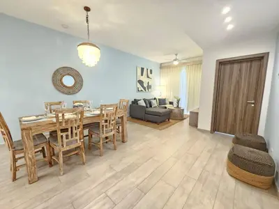 a dining room and living room with a table and chairs at 2BR Beach Condo • Prime Location Across Hard Rock in Punta Cana