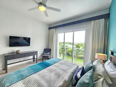 a bedroom with a bed and a large window at 2BR Beach Condo • Prime Location Across Hard Rock in Punta Cana