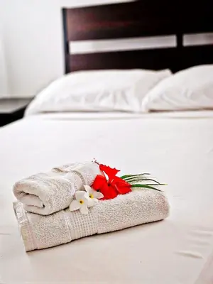 a towel on a bed with flowers on it at Madonna1 pool beach los corales Arenas de Bavaro in Punta Cana
